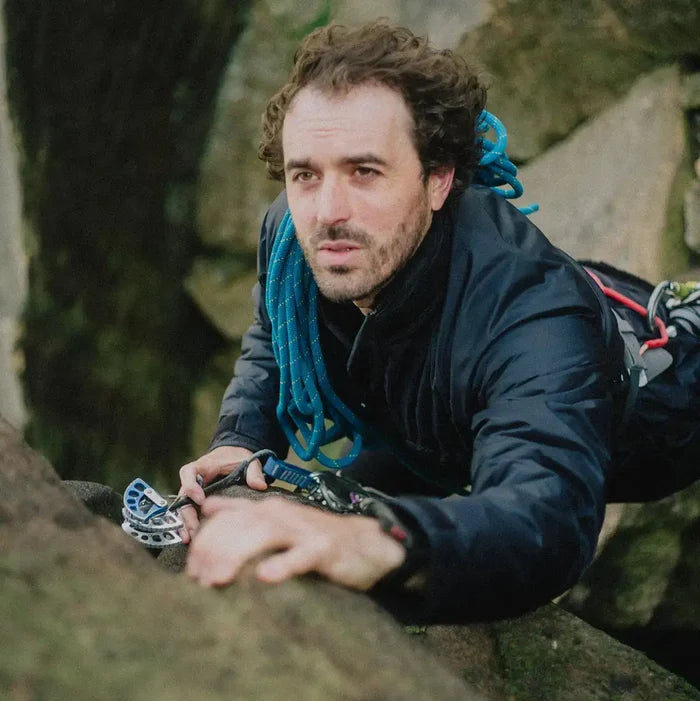 Climber scaling rocks in Buffalo Mens Pertex Belay Jacket, demonstrating its technical design and performance in extreme conditions. from John Bull Clothing