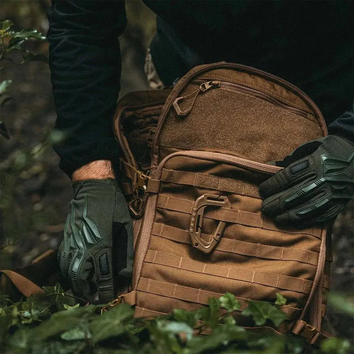 Close-up of Highlander Harrier 35L Full Clamshell Pack in tan, being used outdoors with tactical gloves, highlighting its rugged and functional design. from John Bull Clothing