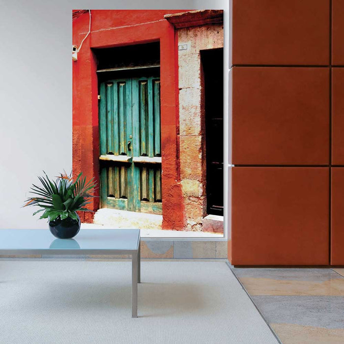 72 inch decal of a red frame with green door of a Mexican home installed installed on a wall with coffee table and plant in foreground