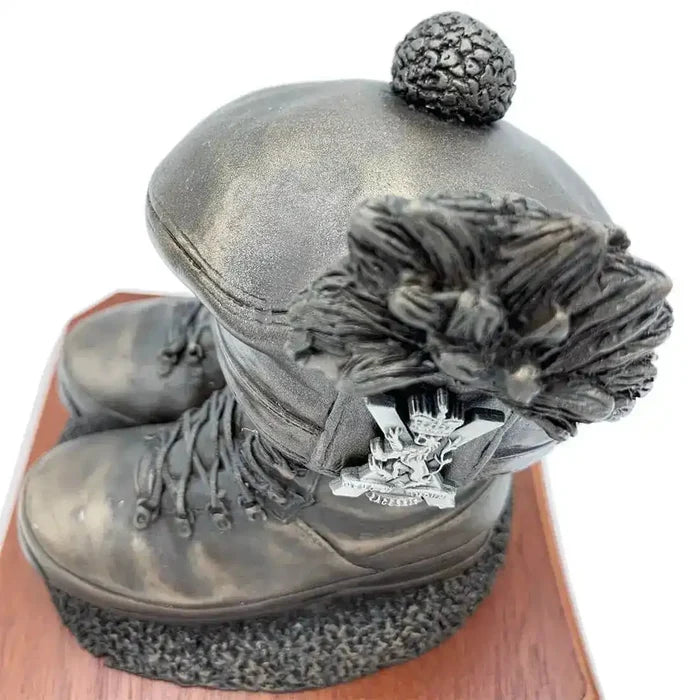 Close-up of Boots and Tam O'Shanter Statue with regimental badge detail on cap. Bronze resin sculpture honoring Scottish military heritage.  from  John Bull Clothing