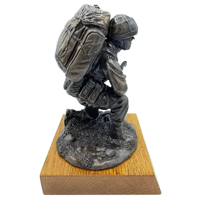 Left profile of Bronze Resin Kneeling Combat Statue with Helmet, showcasing tactical uniform and gear on oak base for military-themed decor.  from  John Bull Clothing