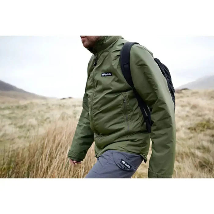 Man hiking in the Buffalo Mens Pertex Belay Jacket in olive green, showcasing its functionality in rugged outdoor terrain.  from  John Bull Clothing