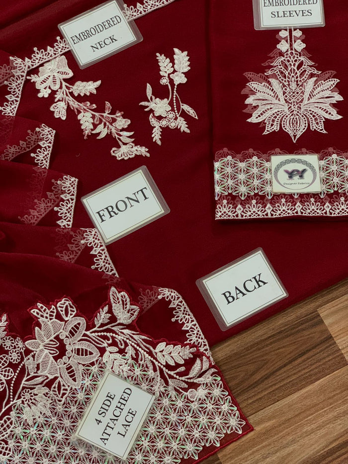 Close-up of white floral threadwork on a burgundy formal dress.
