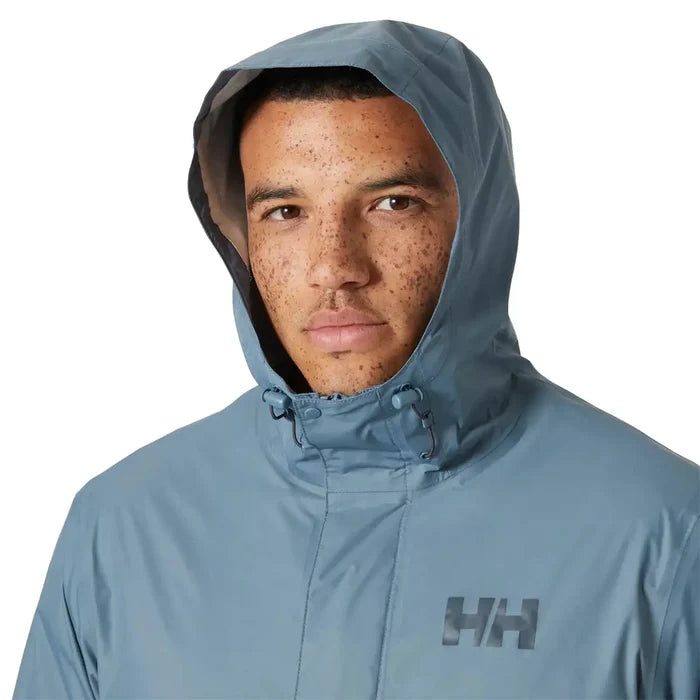 Close-up of model wearing Helly Hansen Mens Loke 2.0 Waterproof Jacket with hood up, showing face coverage and logo detail.  from  John Bull Clothing