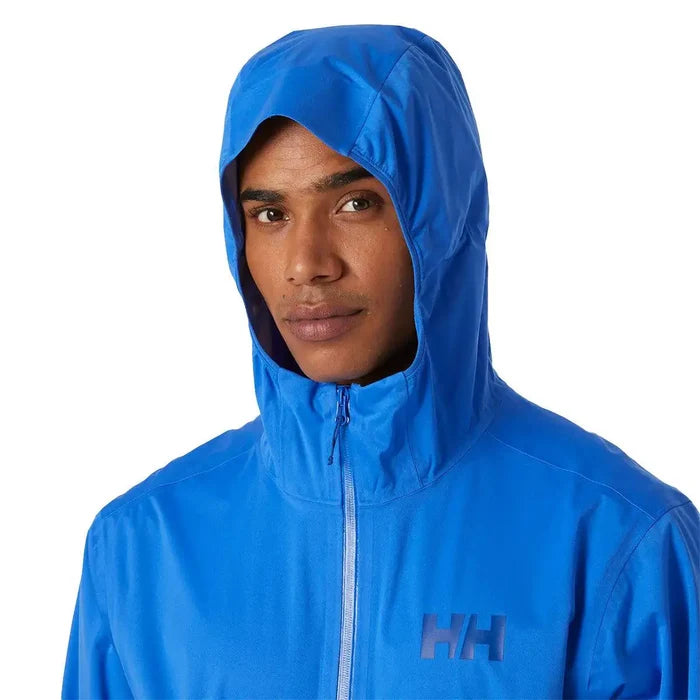 Close-up of model wearing blue Helly Hansen Mens Momentum 3 Layer Stretch Waterproof Jacket with hood up, showing waterproof hood design.  from  John Bull Clothing