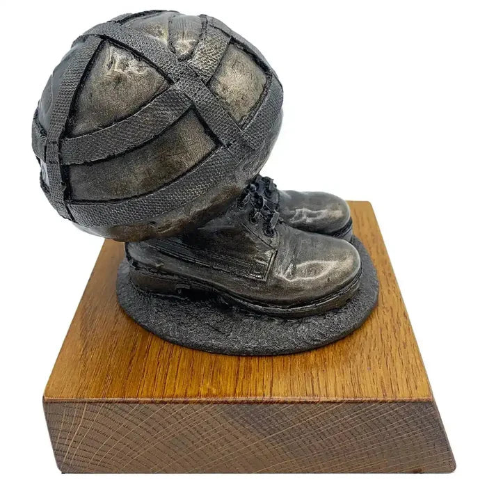 Angled view of Helmet & Boots Bronze Resin Statue highlighting realistic military gear design and sturdy wooden base.  from  John Bull Clothing
