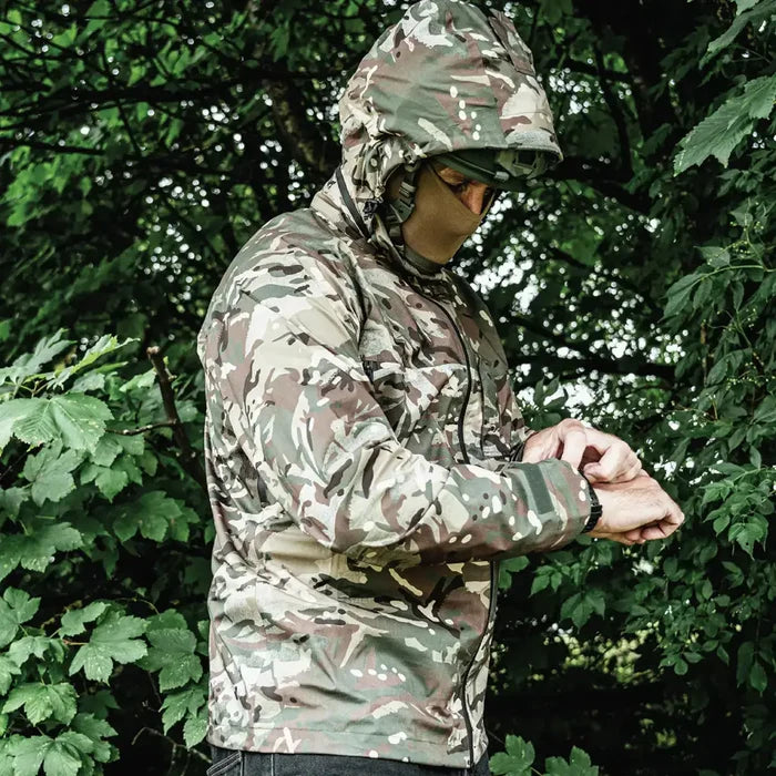 Model wearing Highlander Cyclone Pro Waterproof Jacket in camo outdoors, demonstrating its fit and weatherproof performance.  from  John Bull Clothing