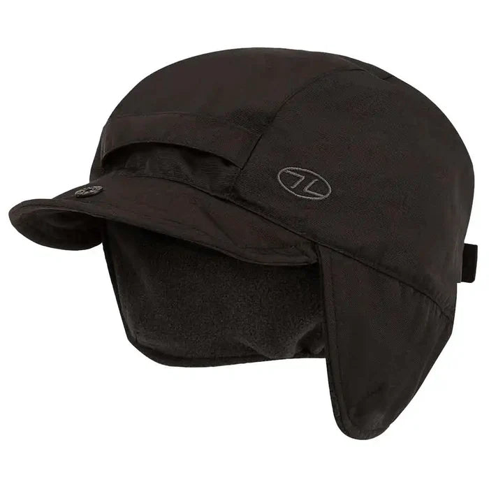 Black Highlander Dry Tech Mountain Waterproof Hat with fleece-lined ear flaps and curved brim, ideal for outdoor winter use. Black from  John Bull Clothing