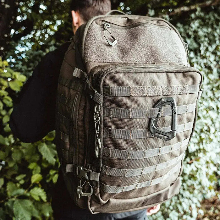 Person wearing the Highlander Harrier 45L Clamshell Backpack in olive green, showcasing its large capacity, tactical design, and outdoor durability.  from  John Bull Clothing