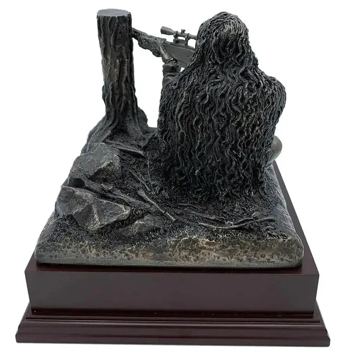 Detailed rear view of Kneeling Sniper Bronze Resin Figurine showing textured ghillie suit and tactical setting on rosewood base for home or office display.  from  John Bull Clothing