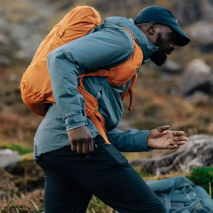 Trail runner wearing the Montane Trailblazer 25L Rucksack in orange, demonstrating its lightweight and ergonomic design.  from  John Bull Clothing