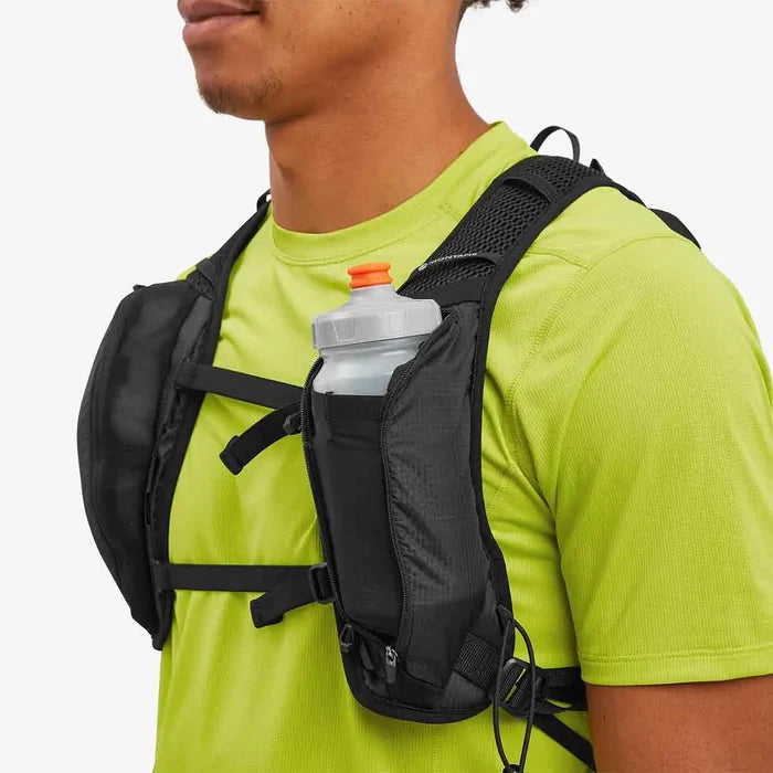 Close-up of a person wearing the Montane Trailblazer 8L Recycled Backpack, showing front storage pockets with a water bottle for easy hydration access.  from  John Bull Clothing