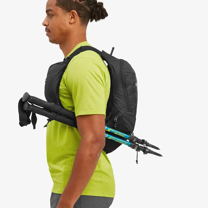 Person wearing the Montane Trailblazer 8L Recycled Backpack with trekking poles attached, showcasing its versatile storage options for outdoor gear and accessories.  from  John Bull Clothing