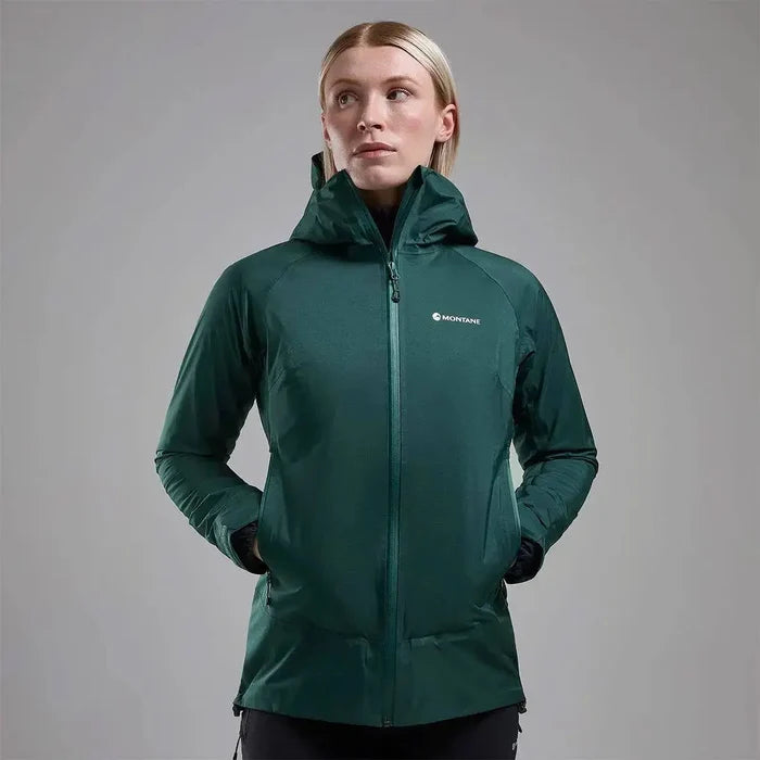 Model wearing Montane Women's Cetus Lite Waterproof Jacket in dark green, showcasing its tailored fit and functional design. Deep Forest from  John Bull Clothing
