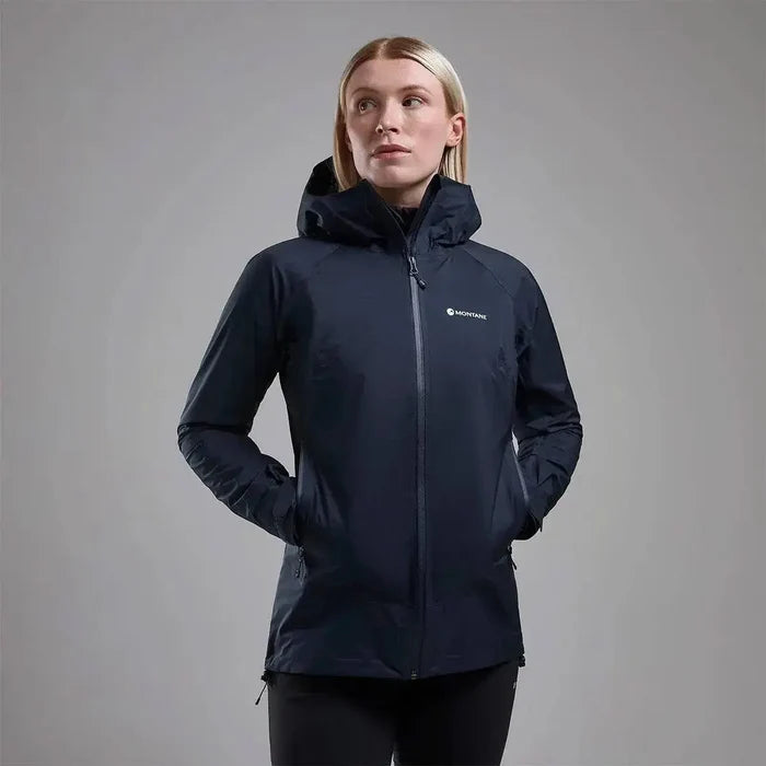 Model wearing Montane Women's Cetus Lite Waterproof Jacket in black, highlighting its sleek design and practical outdoor wearability. Eclipse Blue from  John Bull Clothing