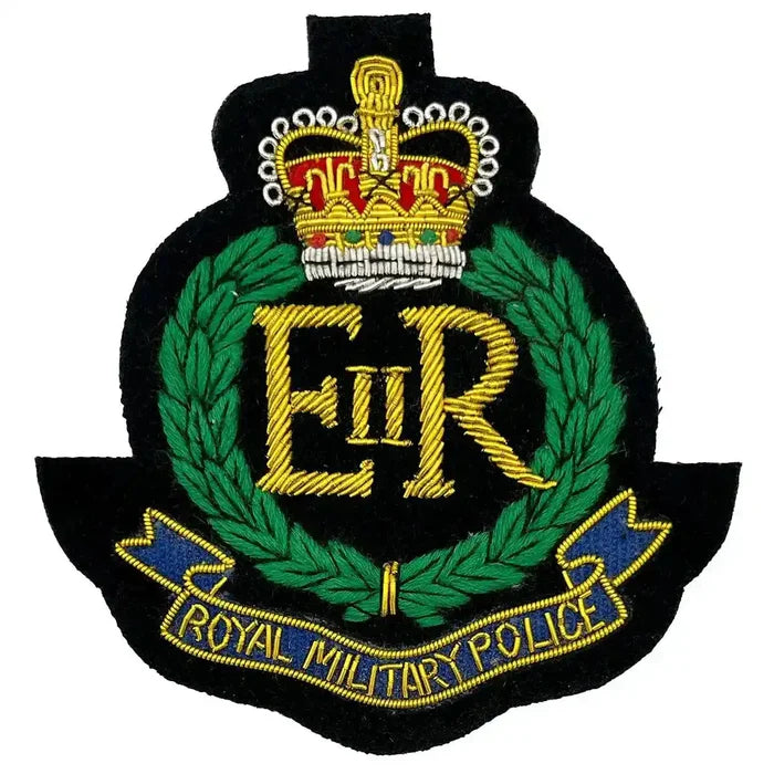 Royal Military Police Blazer Badge featuring gold wire bullion embroidery with crown, laurel wreath, and blue banner on black felt backing.  from  John Bull Clothing
