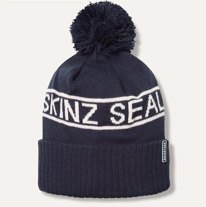 Navy Sealskinz Heacham Waterproof Cold Weather Icon Bobble Hat featuring white logo band and pom-pom, made for cold weather protection. Navy/Cream from  John Bull Clothing