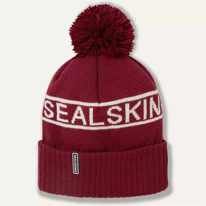Burgundy Sealskinz Heacham Waterproof Cold Weather Icon Bobble Hat with white logo and pom-pom, stylish and functional winter hat.  from  John Bull Clothing