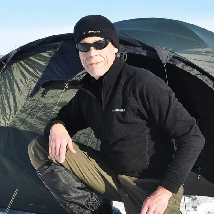 Man wearing Snugpak Impact Black Fleece Shirt in a cold outdoor setting, showcasing its warmth and versatility for camping and outdoor adventures.  from  John Bull Clothing
