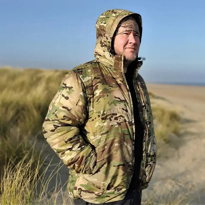 Man wearing Snugpak Spearhead Midweight Insulated Jacket WGTE Multicam outdoors, showcasing its field-ready design and weather protection.  from  John Bull Clothing