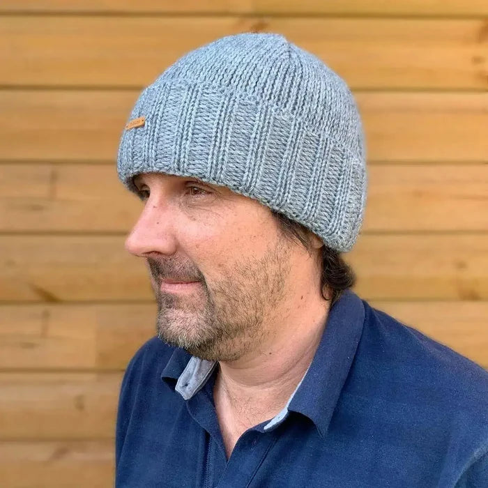 Man wearing the Starling Unisex Rollover Beanie Hat 12033 in grey, made from a warm double-lined wool mix, ideal for cold weather.  from  John Bull Clothing