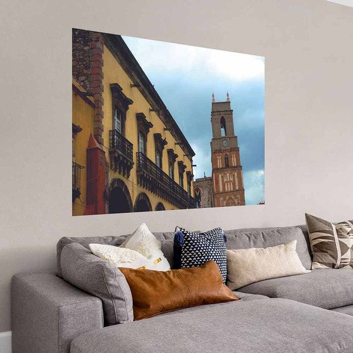 72 inch Mexican cathedral tower and building against a blue sky wall decal installed on wall above a sofa