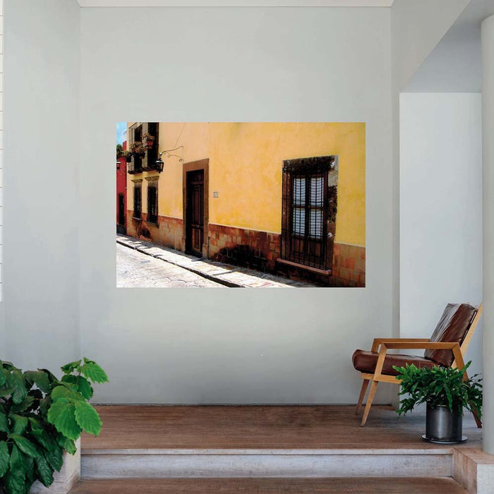 48 inch poster Mexican street and yellow house architecture displayed on a wall above landing