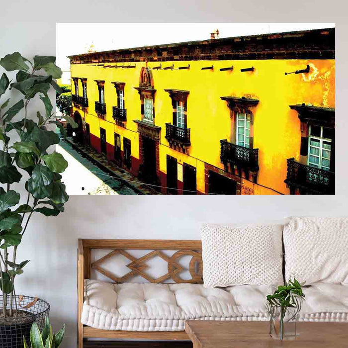 72 inch decal of yellow Mexican hotel with balconies installed on a wall above a wooden bench