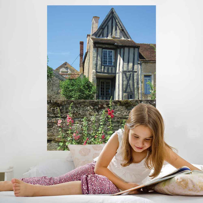 48 inch decal of a half timbered house with a wall and flowers in foreground installed on a wall in a girls bedroom