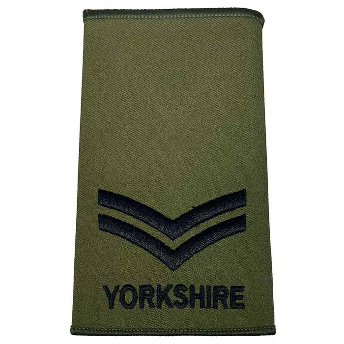 Yorkshire Regiment Rank Slide Olive Green with two black chevrons and 'YORKSHIRE' text, representing a corporal rank. Corporal from  John Bull Clothing